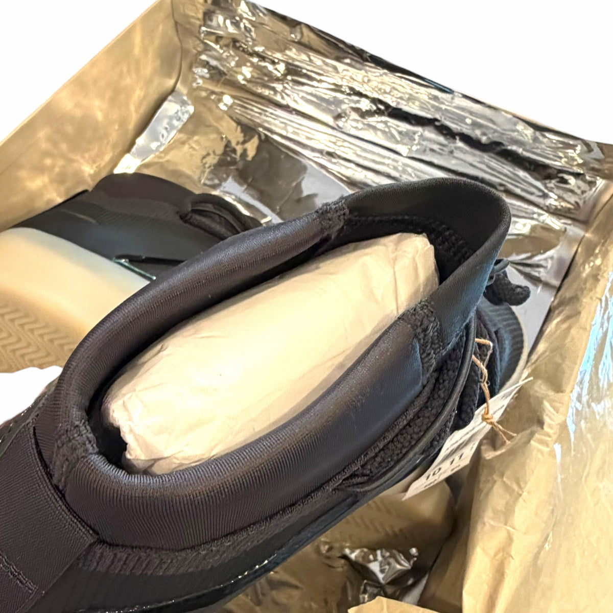 Vangsworld, Inc adidas Fear of God Athletics black high-top basketball sneakers inside a metallic silver shoe box.