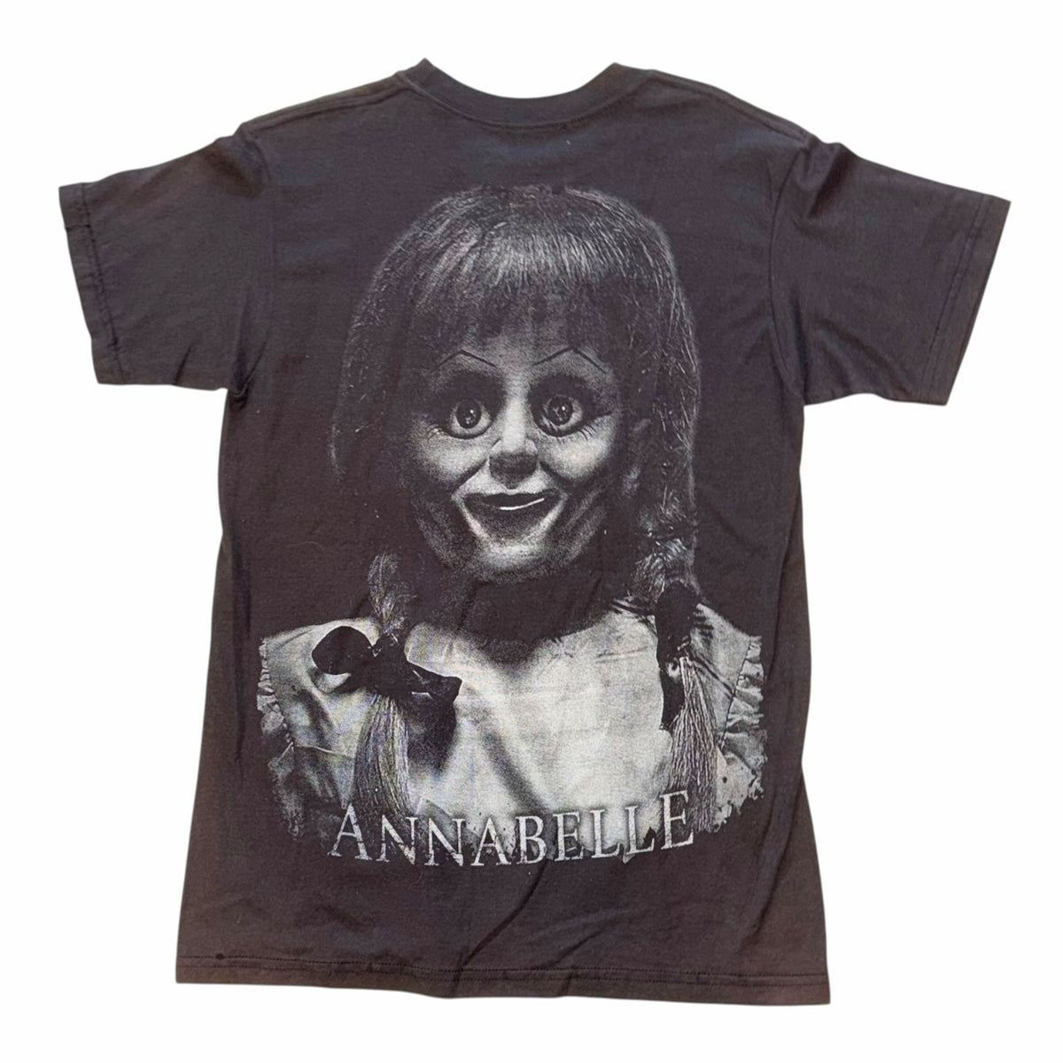 Vangsworld, Inc black cotton t-shirt featuring a detailed Annabelle horror movie doll graphic print on the front.