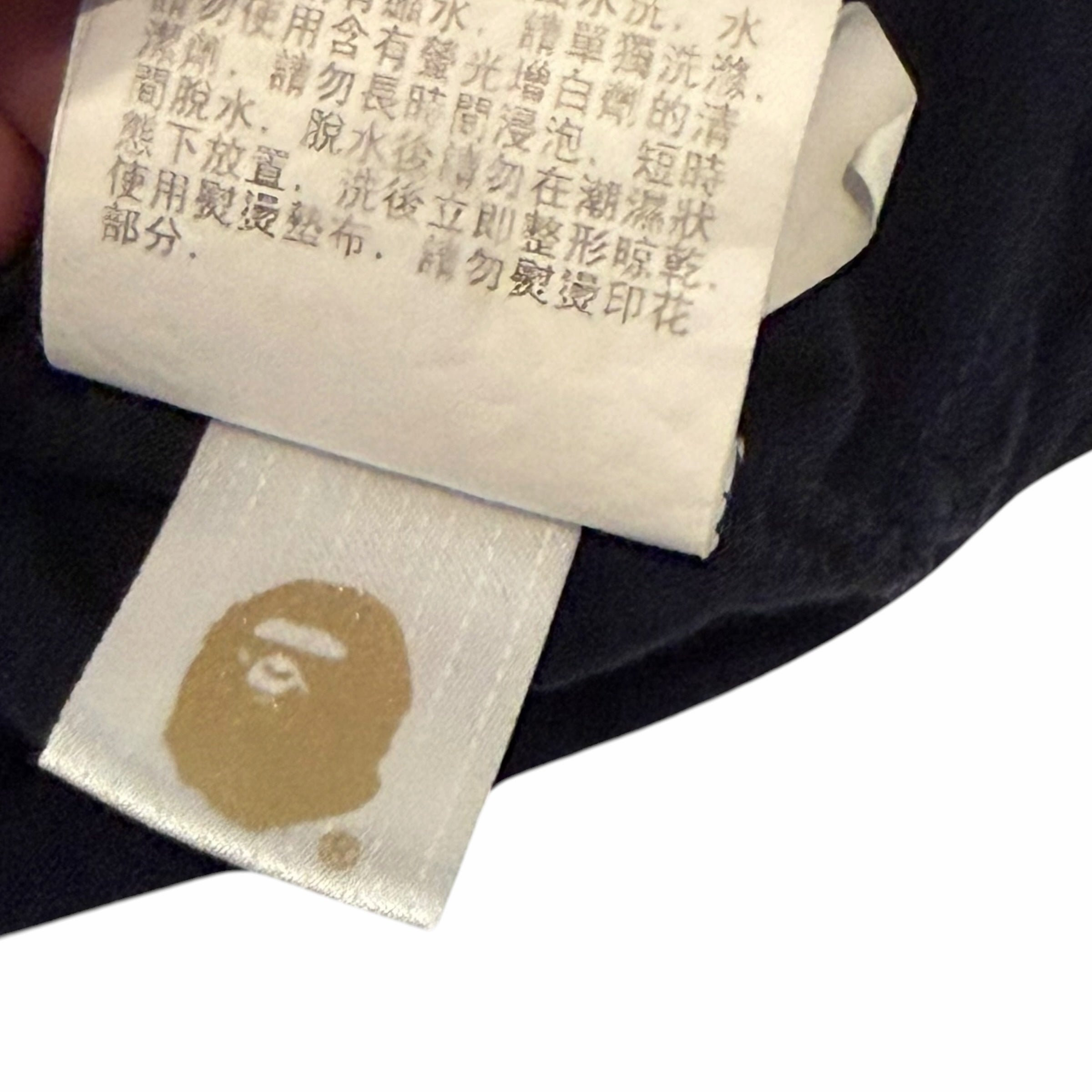 Vangsworld, Inc A BATHING APE X COACH t-shirt interior care label with BAPE ape head logo on a white fabric tab