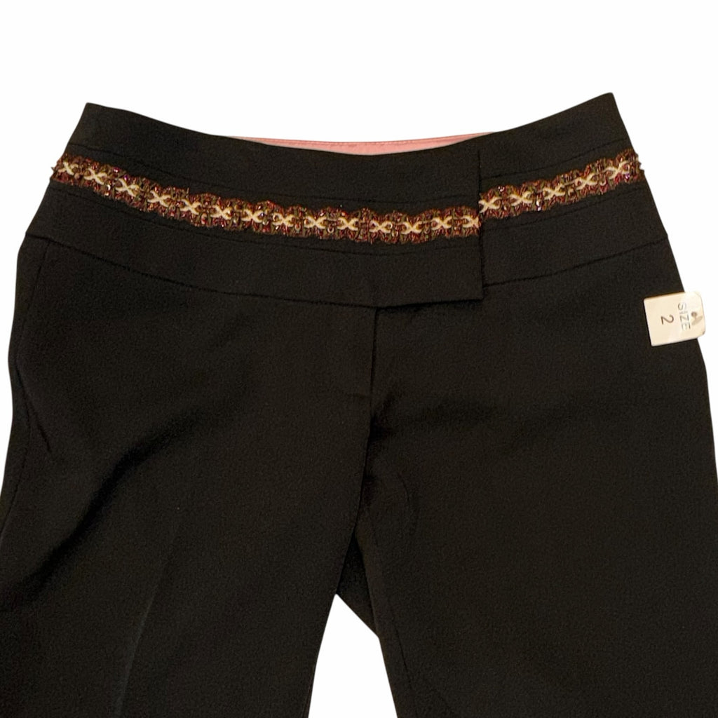 Vangsworld, Inc black dress pants featuring a decorative multi-colored beaded waistband and soft pink interior lining.