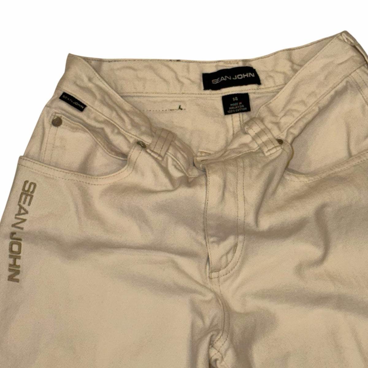Vangsworld, Inc cream 100% cotton Sean John denim jeans with signature embroidery and classic five-pocket design.