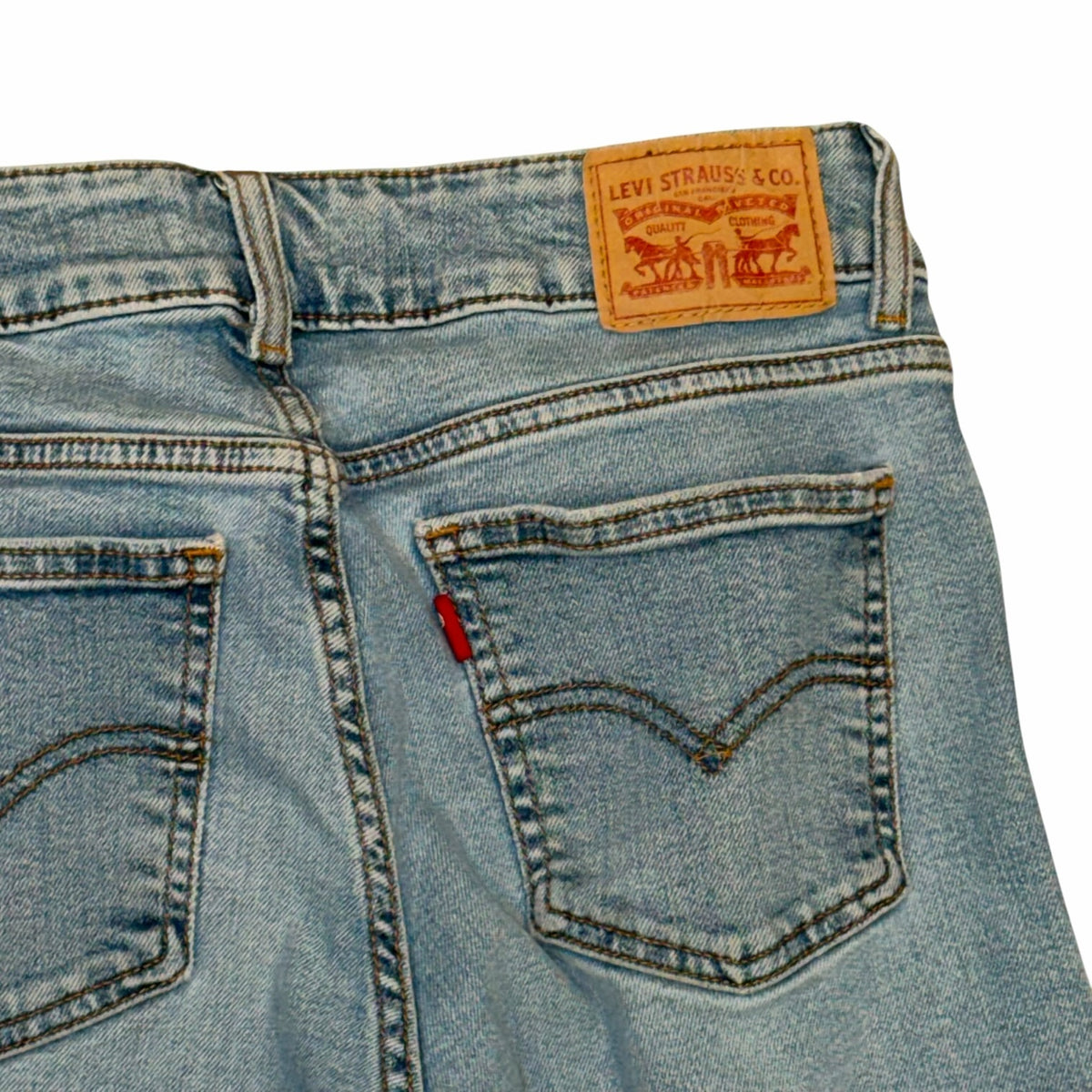 Vangsworld, Inc light-wash blue denim jeans featuring a signature Levi's leather back patch and iconic red tab detail.