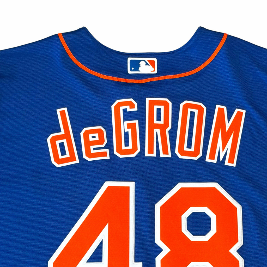 Vangsworld, Inc New York Mets Jacob deGrom jersey in royal blue with orange lettering and MLB logo on the back neck.