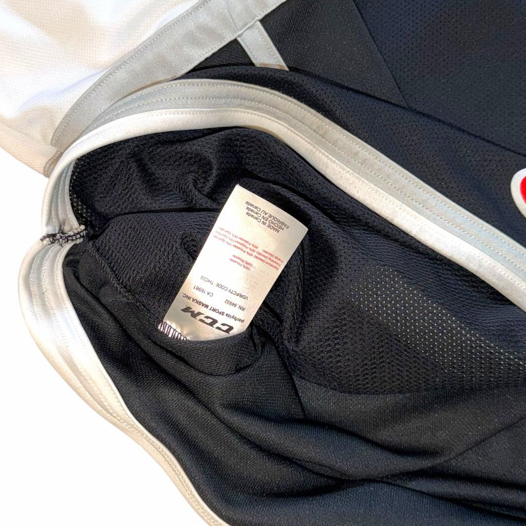Vangsworld, Inc Ontario Reign hockey jersey interior showing CCM brand label and fabric care tag on black mesh