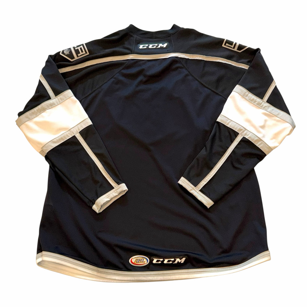 Back view of Vangsworld, Inc Ontario Reign CCM hockey jersey in black, white, and silver polyester mesh.