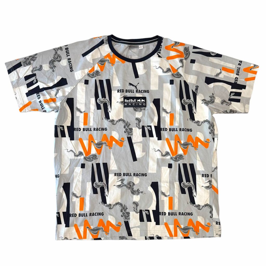Vangsworld, Inc PUMA Red Bull Racing graphic t-shirt in grey, white, orange, and navy with abstract motorsport print.