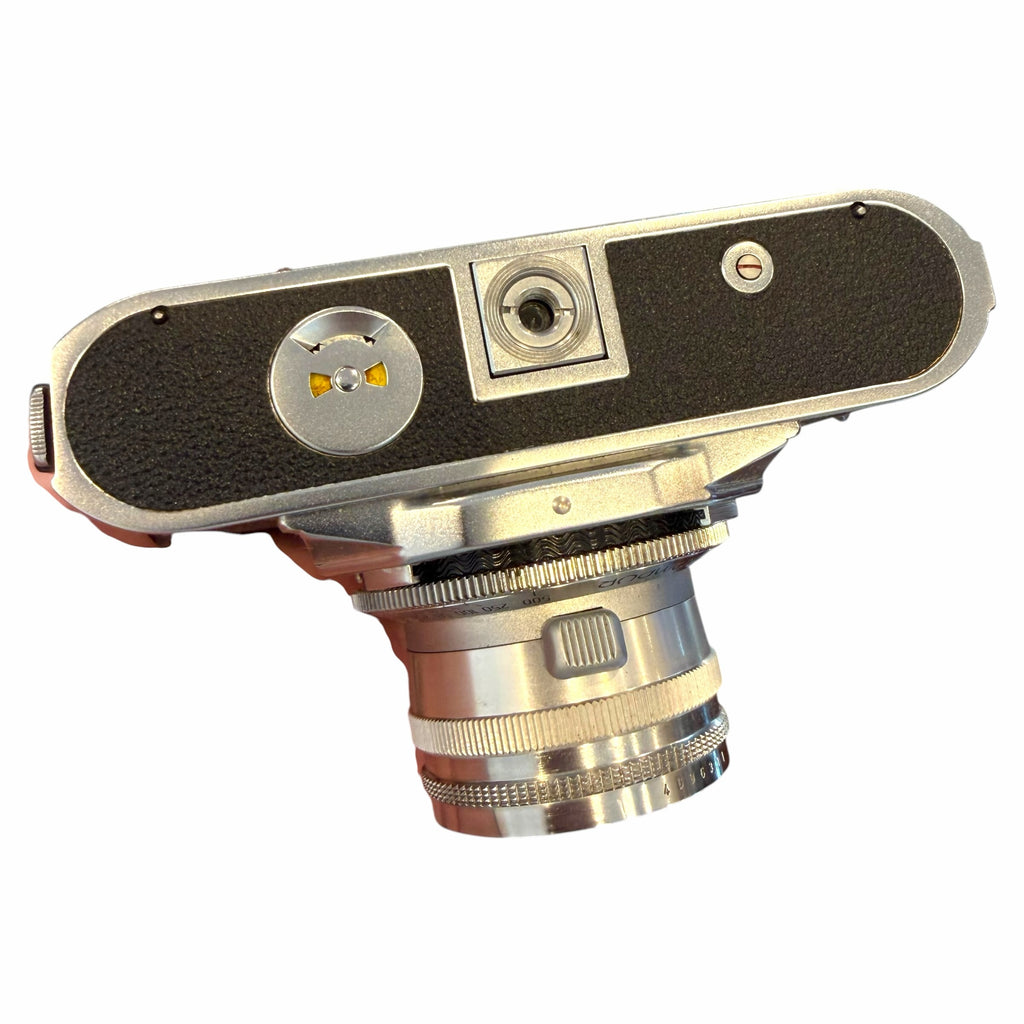 Vangsworld, Inc vintage Voigtländer rangefinder film camera with silver metal body and Nokton 50mm lens, bottom view.